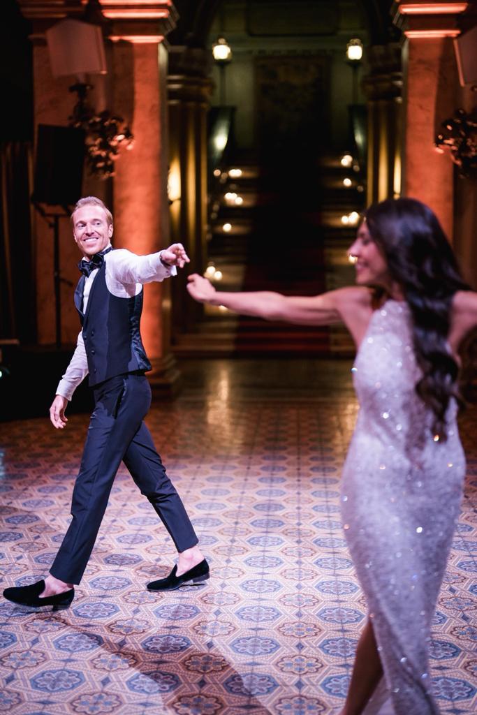 Newlyweds dancing together confidently in front of guests