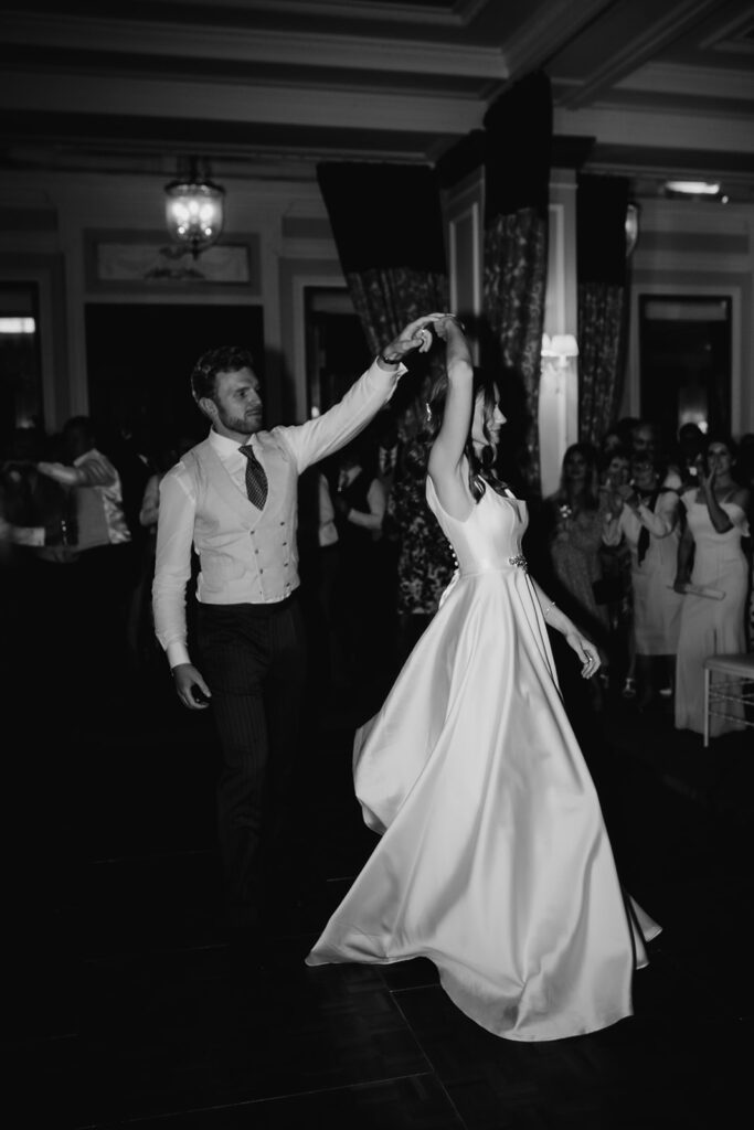 Romantic first dance between newlyweds surrounded by guests